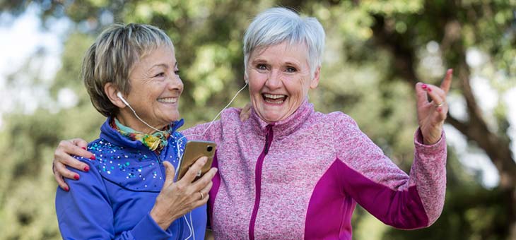 two older women having fun and exercising in the park